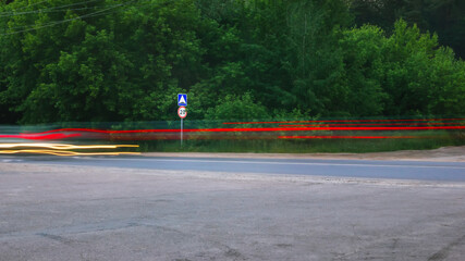 Blurred Glowing Lines of Headlights and Traffic Sign on the Country Road - 356778443