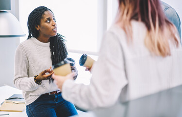 Back view of young staff member communicating with afro american student 