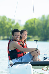 couple erecting sail on boat