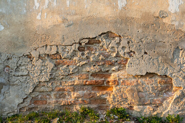 Old brick wall with destroyed plaster
