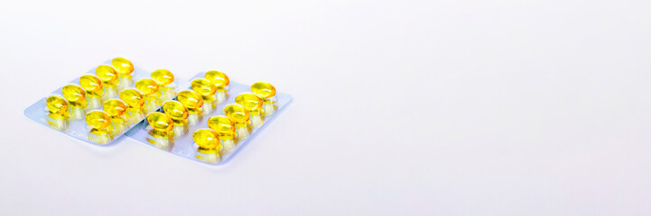 Yellow transparent pills in clear plastic blisters on white background. Medical concept.