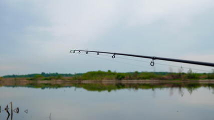 Feeder fishing on the lake. Focus on fishing rod.