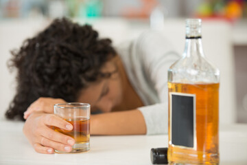 unconscious drunk woman and glass of whiskey