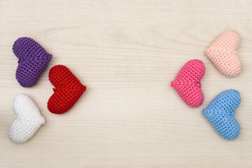 Fototapeta na wymiar Colorful crochet hearts on a wooden background.
