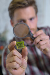 jeweler looking at diamond through loupe to inspect it