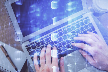 Multi exposure of man's hands typing over computer keyboard and data theme hologram drawing. Top view. Technology concept.