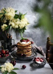 Naklejka na ściany i meble Breakfast Pancakes with Cherries, Homemade American pancakes served withfresh cherry on a wooden background, sweet dessert 