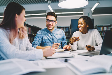 Positive experienced male marketing expert explaining for good looking female colleagues general working concepts 