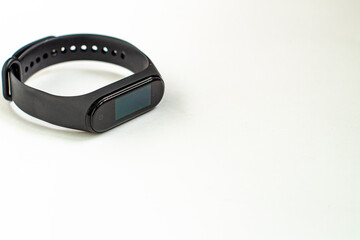 Black fitness bracelet on a white background for heart rate measurement close up