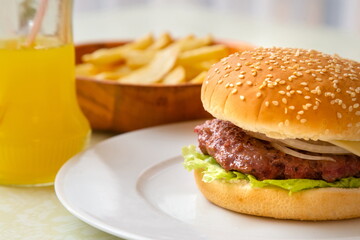 Burger with potatoes and soft drink in restaurant