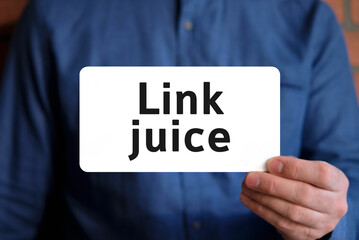 Link juice text on a white sign in the hand of a man in a blue shirt