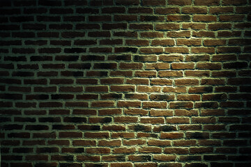 Urban texture of a brick wall with a light spot.