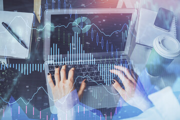 Double exposure of woman hands typing on computer and forex chart hologram drawing. Stock market...
