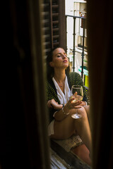Fashion woman enjoying her white wine on the balcony