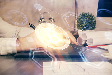 Double exposure of man's hands holding and using a phone and crypto currency blockchain theme drawing.