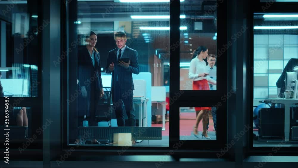 Poster footage from outside: businesswoman and businessman in a suit working on a tablet computer in the of