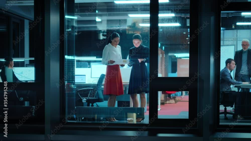 Aufkleber footage from outside: two businesswomen working on a tablet computer in office. managers standing by