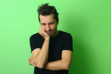 Young man or guy on a light green background. Emotion of resentment