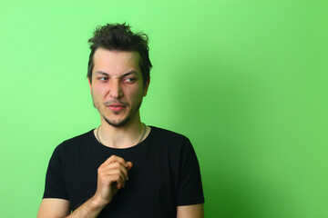 young man or guy on a light green background. Emotion of contempt