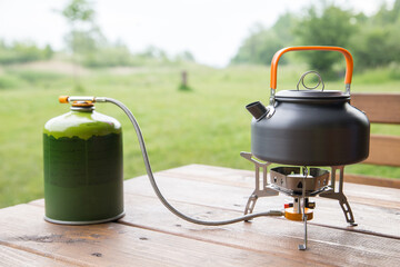 kettle stands for making coffee or tea on a gas tourist burner with a gas cylinder in the campsite