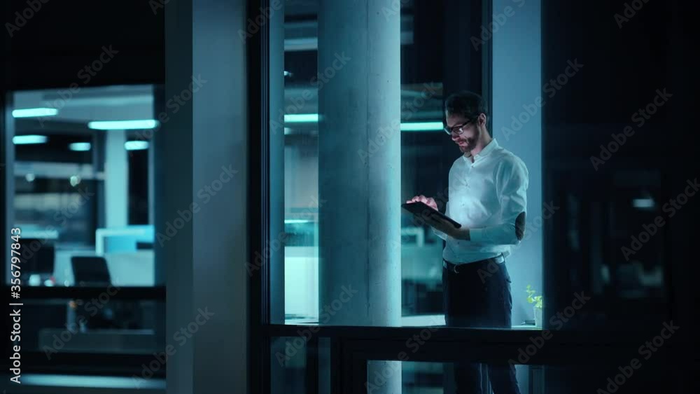 Poster Footage from Outside: Businessman Working on a Digital Tablet Computer in the Office. Manager Checking Emails while Standing by the Window. Employee Planning Financial Tasks and Business Development.