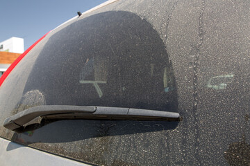 back window wiper blade of a dirty car covered in dry mud side view of a 4x4 suv vehicle muddy...