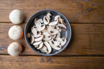 sliced mushrooms lie in a pan