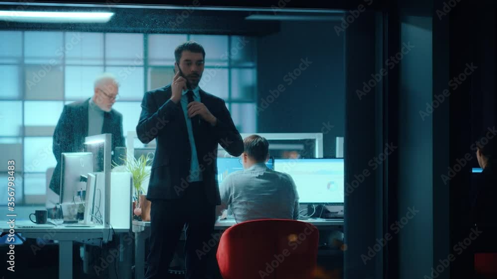 Aufkleber Footage from Outside: Businessman Talking on a Mobile in the Office. Manager is Having a Business Call while Standing by the Window. Employee Planning Financial Tasks and Business Development.