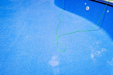 A hose to clean an empty swimming pool in summer.