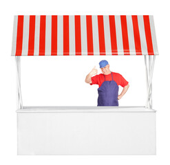 Man seller and street market stand stall with red white striped awning 