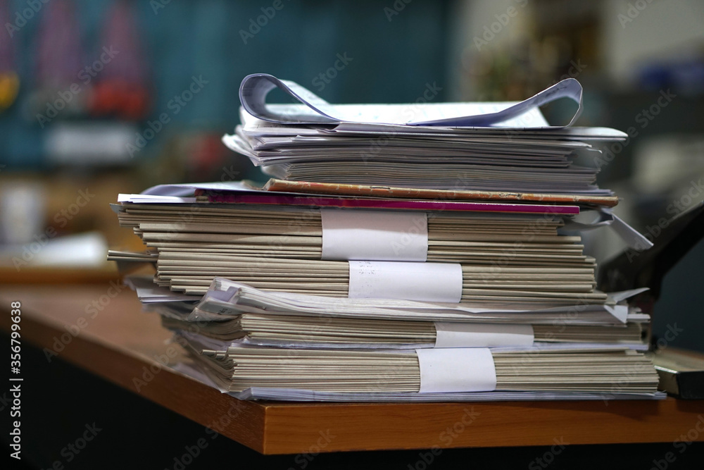 Poster stack of business report paper files on desk