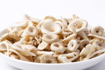 fresh whole mushrooms in a dish on white background