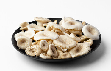 fresh whole mushrooms in a dish on white background