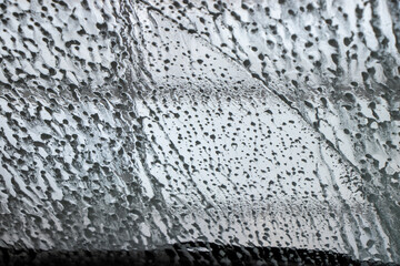 view through the windshield in a car wash of soapy water on the glass
