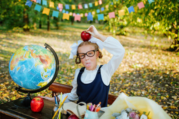 schoolgirl at a school desk holds on her head a newton's apple