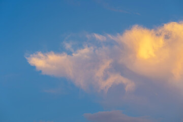 Fototapeta na wymiar Evening orange clouds moving in blue sky
