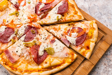 Sliced Homemade pizza With pepperoni and cheese on a wooden cutting Board on the table closeup. Selective focus