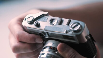 A vintage retro professional camera device settings being adjusted by a photographer . Old technology concept.
