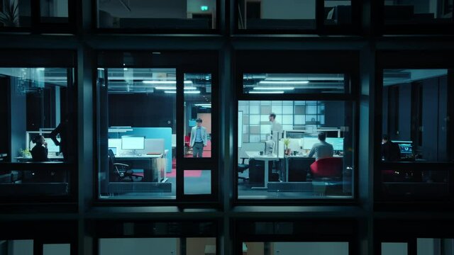 Timelapse Footage from Outside the Window: Businessmen and Businesswomen Working in the Office. Managers Doing Financial Tasks and Errands. Employees Work on Computers, Mobile Phones, Tablets.