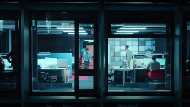 Timelapse Footage from Outside the Window: Businessmen and Businesswomen Working in the Office. Managers Doing Financial Tasks and Errands. Employees Work on Computers, Mobile Phones, Tablets.