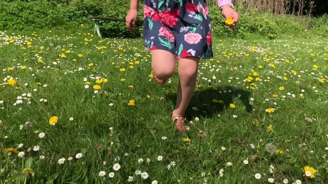 Young child running free in the springtime surrounded by wild flowers