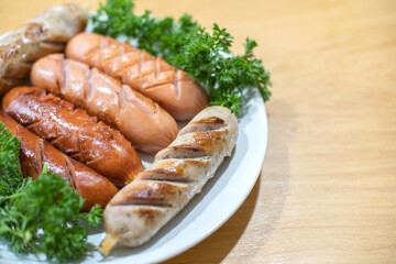 Breakfast grilled pork sausages on white disc.