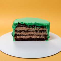 half of chocolate cake on yellow background