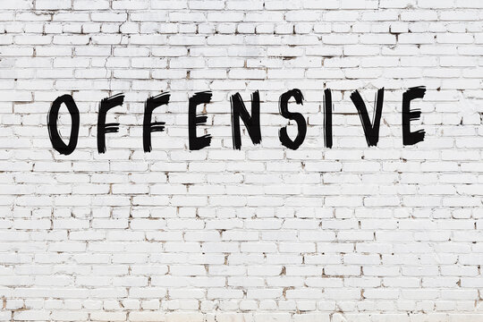 Word Offensive Painted On White Brick Wall