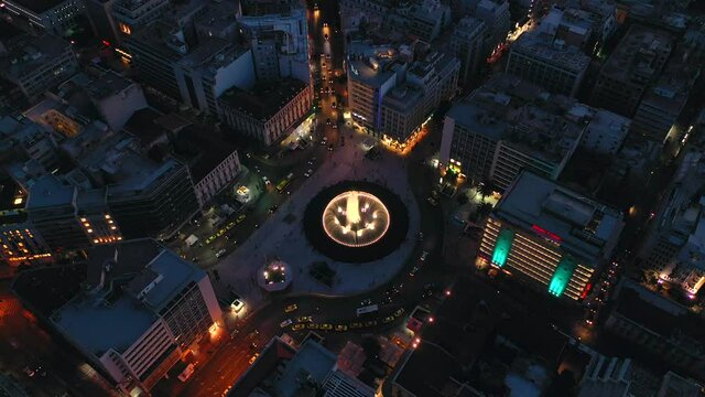 Omonia Square fountaine ans circle traffic around at night time, Athens city skyline 4k