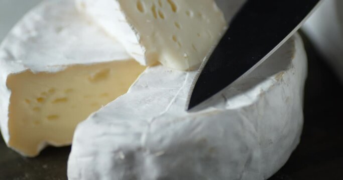 Camembert cheese with knife rotates slowly.