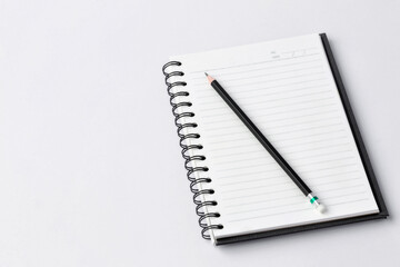 Notebook and pencil on white background