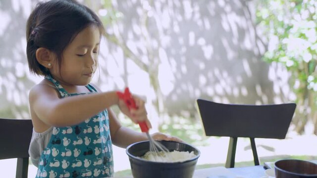 Beautiful Japanese Girl stiring flour mix