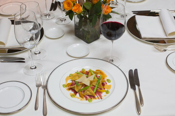 Ravioli on a plate with asparagus and Red wine