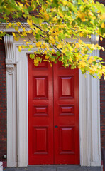 Fototapeta na wymiar Closeup of a red door in a building facade